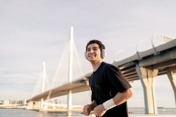 Fototapeta na wymiar A male runner wearing headphones, using an application in a smartwatch for music for training.