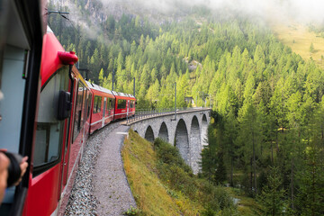 Train of Rhaetian Railway riding over viaduct in canton Graub&uuml;nden, South-East Switzerland
