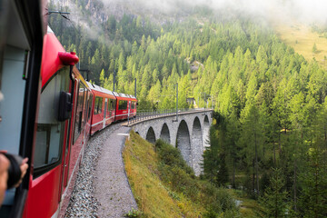 Train of Rhaetian Railway riding over viaduct in canton Graubünden, South-East Switzerland