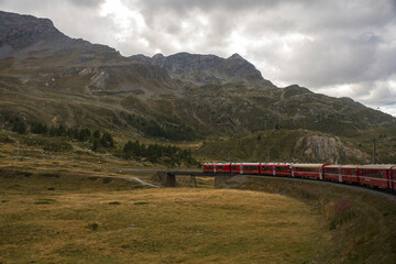 Fototapeta na wymiar Train of Rhaetian Railway riding in a mountain landscape in canton Graubünden, South-East Switzerland