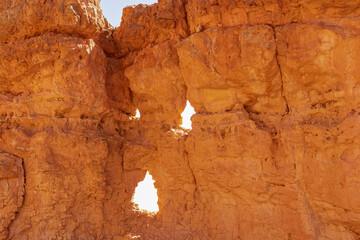 Scenic view on holes in pinnacle rock looking like a face on Peekaboo hiking trail, Bryce Canyon National Park, Utah, USA. Hoodoo sandstone rock formations in natural amphitheatre in summer
