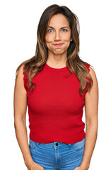 Obraz premium Young hispanic woman wearing casual clothes puffing cheeks with funny face. mouth inflated with air, crazy expression.