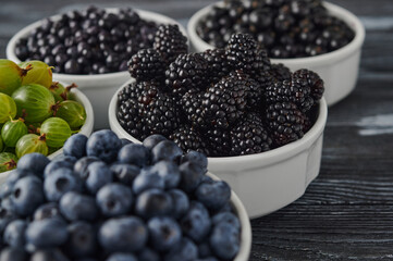ripe blackberries in white bowls on the table