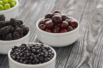 ripe cherries in white bowls on the table