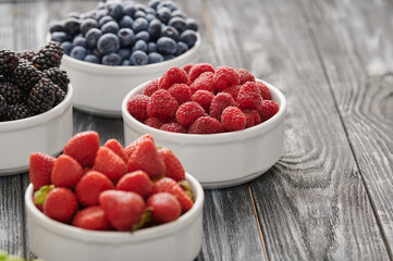 raspberries in a white bowl, blueberries, gooseberries, raspberries, blackcurrants, close-up shot
