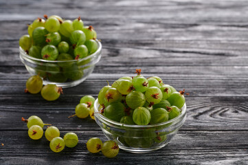 ripe gooseberries on a wooden table in glass plates