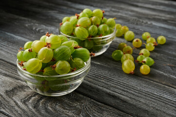 ripe gooseberries on a wooden table in glass plates