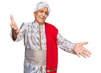 Senior hispanic man wearing tradition sherwani saree clothes looking at the camera smiling with open arms for hug. cheerful expression embracing happiness.