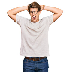 Handsome caucasian man wearing casual clothes and glasses crazy and scared with hands on head, afraid and surprised of shock with open mouth