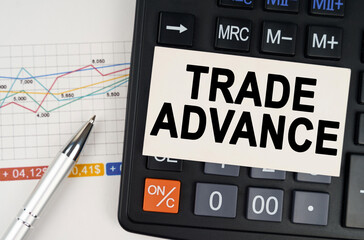 On the business chart lies a pen, a calculator and a business card with the inscription - trade advance