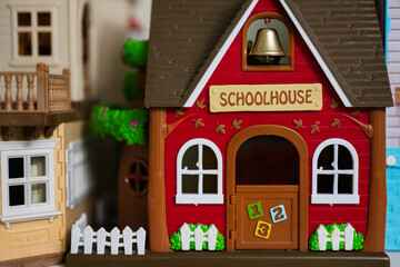 Red school house with bell plastic toy.