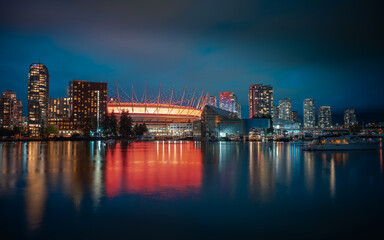 Fototapeta na wymiar Long exposure night photograph of the illuminated city of Vancouver, Canada, and its reflection in the water.