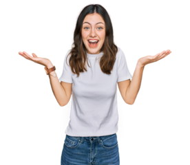 Young beautiful woman wearing casual white t shirt celebrating crazy and amazed for success with arms raised and open eyes screaming excited. winner concept