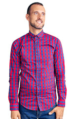 Fototapeta premium Young handsome man wearing casual clothes looking away to side with smile on face, natural expression. laughing confident.