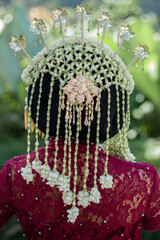 Indonesian wedding accessories. A female model who wears make-up and a traditional wedding dress or attire. Portrait of a traditional Javanese bride. Indonesian bride. Red wedding dress.