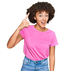 Young hispanic girl wearing casual clothes pointing finger up with successful idea. exited and happy. number one.