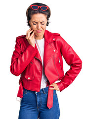 Fototapeta premium Young beautiful woman wearing red leather jacket touching mouth with hand with painful expression because of toothache or dental illness on teeth. dentist