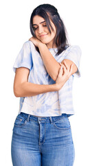 Fototapeta premium Young beautiful girl wearing casual t shirt hugging oneself happy and positive, smiling confident. self love and self care
