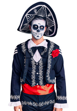 Young man wearing day of the dead costume over background smiling looking to the side and staring away thinking.