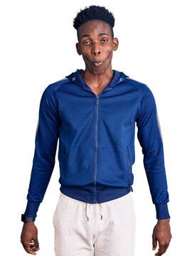 Young african american man wearing sportswear making fish face with lips, crazy and comical gesture. funny expression.