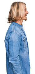 Caucasian man with blond long hair wearing casual denim jacket looking to side, relax profile pose with natural face and confident smile.
