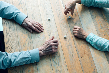 older people gambling with dice detail of hands
