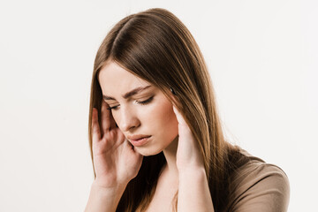Migraine is a strong headache of girl isolated on white background. Overstressed young woman touches her head because of pain. Depression of attractive girl.