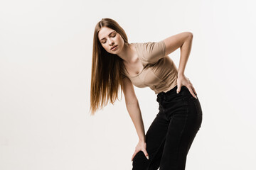 Tired girl holding on to her sore back. Scoleosis and osteochondrosis. Attractive girl feel spine...