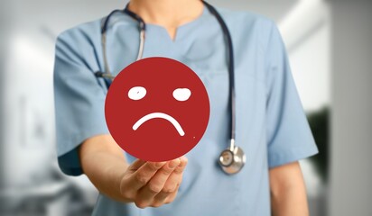 Medical doctor holding angry emoticon in hand