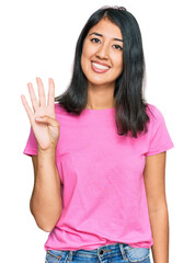 Beautiful asian young woman wearing casual pink t shirt showing and pointing up with fingers number four while smiling confident and happy.