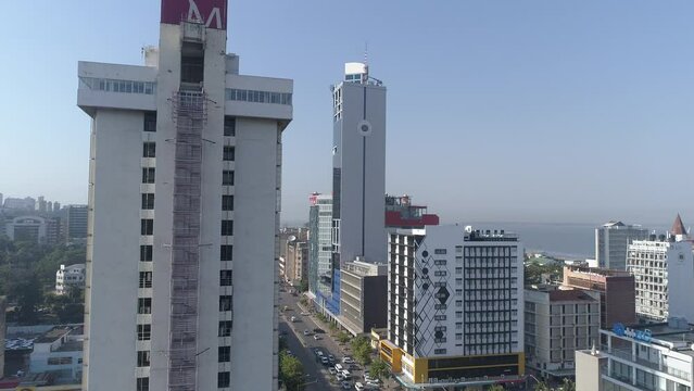 Aerial drone view of Avenida 25 de Setembro in Maputo City, Mozambique, showcasing the coastal area near the Bank of Mozambique, with modern architecture, bustling streets