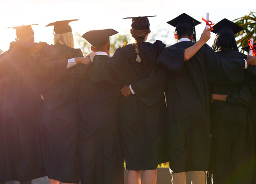 Weve come so far together. Rearview shot of a group of university students standing together on graduation day.