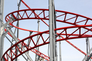 Metal roller coaster close up with red rails