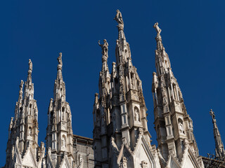 looking Duomo di Milano meaning Milan Cathedral in Italy, with blue sky in winter time