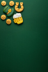 Vertical banner for St. Patrick's Day on green background. Coins, horseshoes, four-leaf clover as...