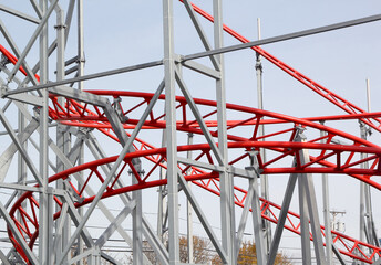 Metal roller coaster close up with red rails