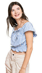Fototapeta premium Young beautiful caucasian girl wearing casual clothes looking away to side with smile on face, natural expression. laughing confident.