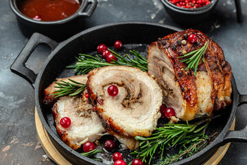 roast pork roulade Porchetta, delicious pork with cranberry berries on a dark background....