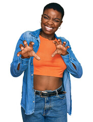 Young african american woman wearing casual clothes smiling funny doing claw gesture as cat,...
