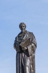 Obraz premium The monument to the Dutch lawyer Hugo Grotius (Hugo de Groot, 1886) on the market square in the Dutch city of Delft. Delft, the Netherlands.