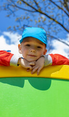 boy toddler climbing on the outdoor climbing wall in the playground