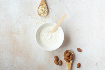 Composition of almonds and sesame seeds in wooden spoons. The concept of proper nutrition, healthy lifestyle, healthy fats and oils. 