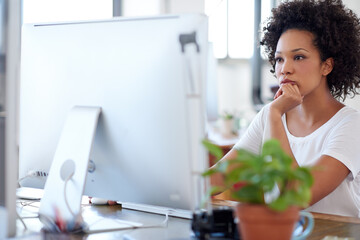 Deeply involved with solution seeking processes. Confident woman working at her desk in an open office space.