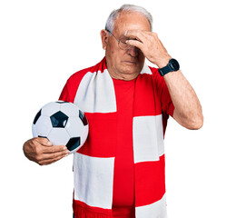 Senior man with grey hair football hooligan holding ball tired rubbing nose and eyes feeling fatigue and headache. stress and frustration concept.