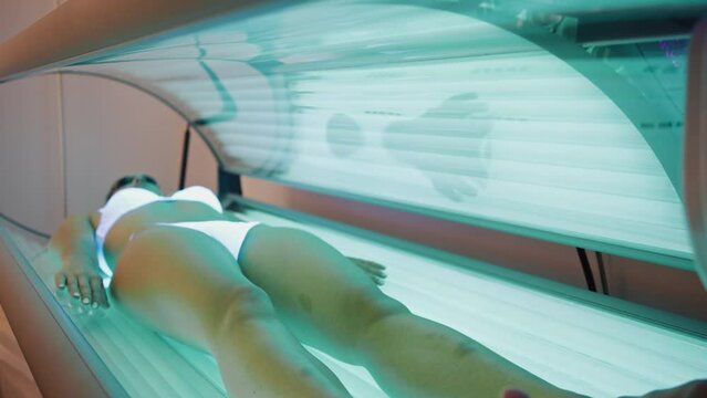 Video of beautiful woman having tanning skin treatment in a solarium