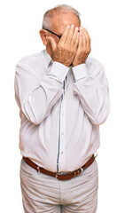 Senior caucasian man wearing business shirt and glasses with sad expression covering face with hands while crying. depression concept.