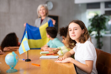 in geography lesson, elderly teacher very eloquently tells children about history of ancient Sweden