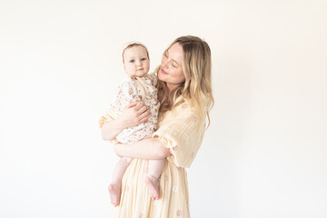 mother and baby daughter with floral dress and bonnet