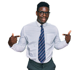 Handsome business black man wearing white shirt and tie looking confident with smile on face, pointing oneself with fingers proud and happy.