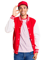 Young african amercian man wearing baseball uniform smiling positive doing ok sign with hand and fingers. successful expression.